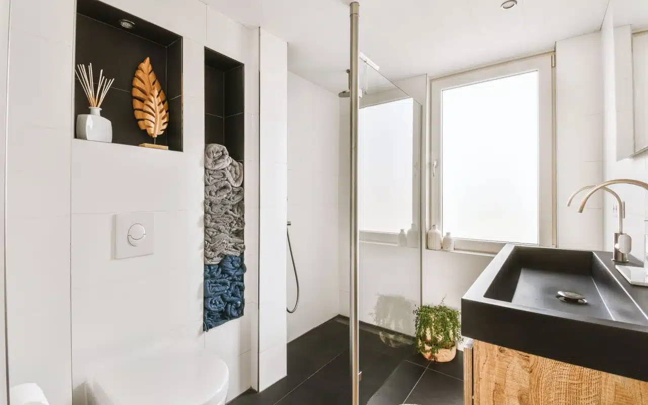 Small bathroom in a modern apartment with toilet, basin and tiled walls