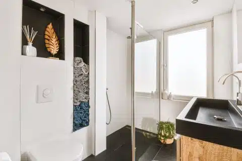 Small bathroom in a modern apartment with toilet, basin and tiled walls