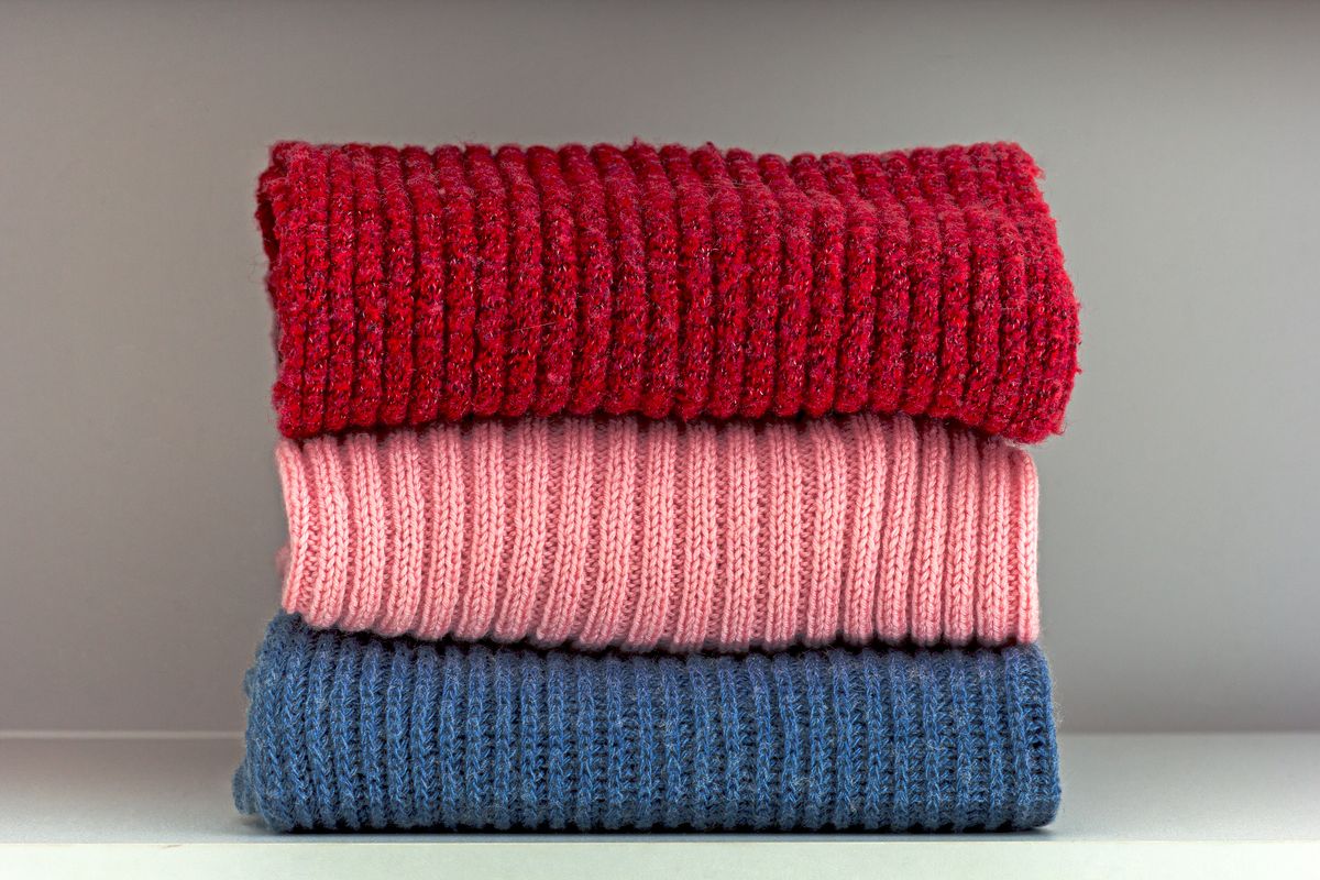 Folded wool cloth stacked on a storage shelf