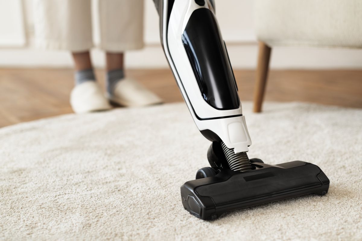 Vacuum cleaner head running over a rug on the floor