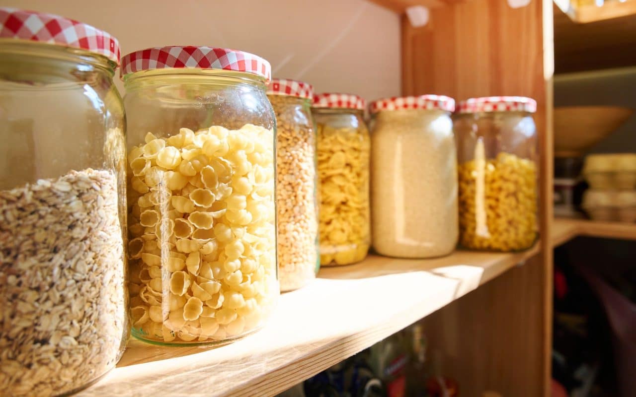Kitchen pantry storage with dry food kept in lidded jars and containers