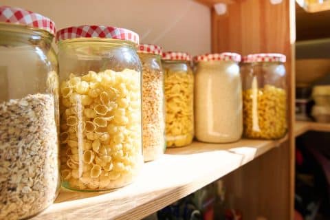 Kitchen pantry storage with dry food kept in lidded jars and containers