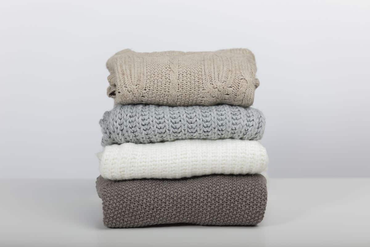 Folded wool sweaters stacked neatly ready to be put away
