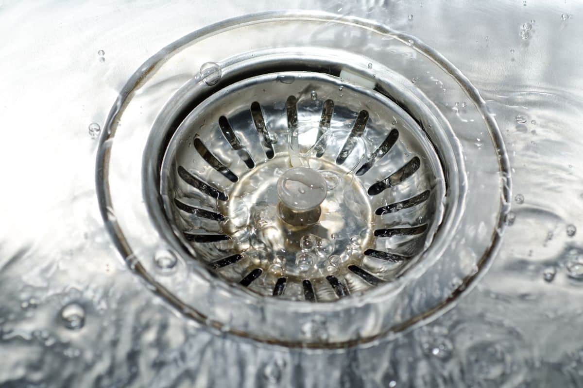 Water running into an open sink drain, seen from above