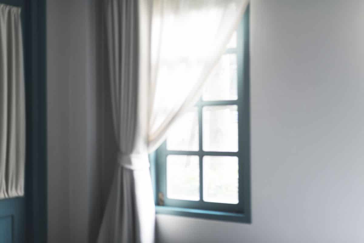 Sunlit living-room window with daylight falling across the sill and frame